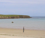 A figure standing alone on an empty beach